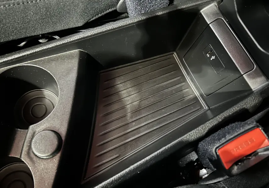 Gros plan sur la console centrale noire de la BMW Série 2 Active Tourer 216d, avec porte-gobelets et port USB visible.