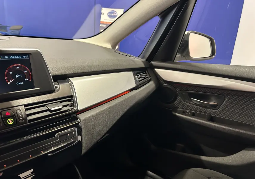 Vue intérieure côté passager de la BMW Série 2 Active Tourer 216d 2021, avec tableau de bord et garnitures noires et argentées.
