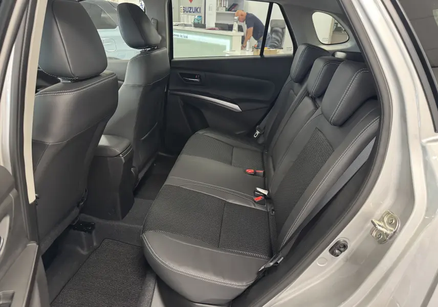 Vue intérieure côté droit des sièges arrière en cuir noir du Suzuki S-Cross gris 2025, avec surpiqûres blanches visibles.