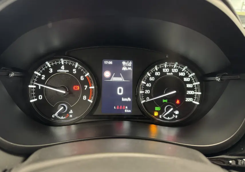 Vue rapprochée du tableau de bord du Suzuki S-Cross gris 2025, affichant compte-tours, vitesse et voyants allumés.