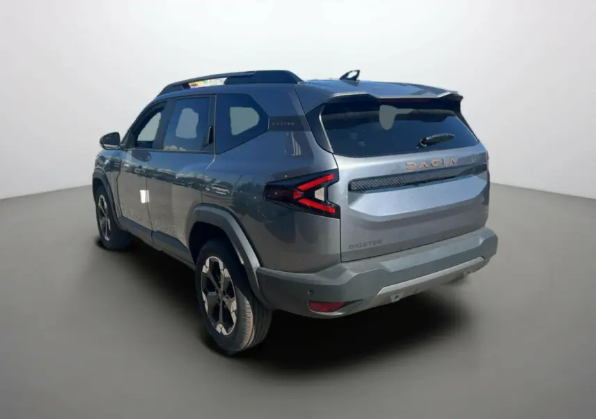 Vue 3/4 arrière droite du Dacia Bigster gris schiste 2025 avec logo et feux arrière en forme de flèche.