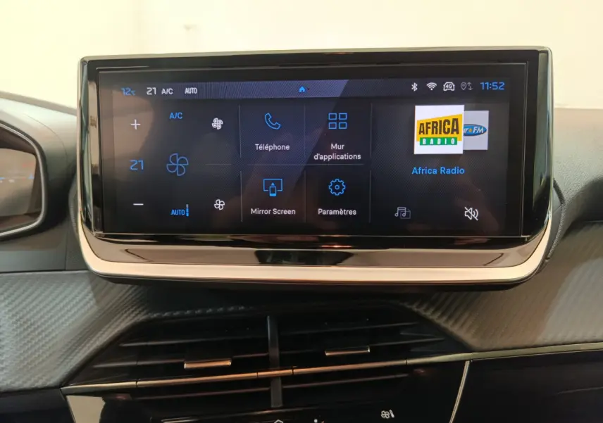 Écran tactile central de 10 pouces affichant les commandes multimédia et climatisation dans une Peugeot 208 gris clair.