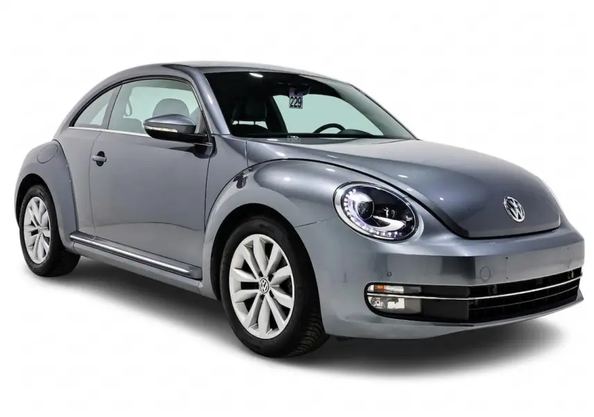 Vue 3/4 avant gauche d'une Volkswagen Coccinelle gris métallisé avec phares LED et jantes alliage.