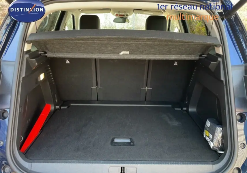 Coffre ouvert vu de l'arrière d'un Citroën C5 Aircross bleu Eclipse Metal, montrant l'espace de chargement et la tablette cache-bagages.