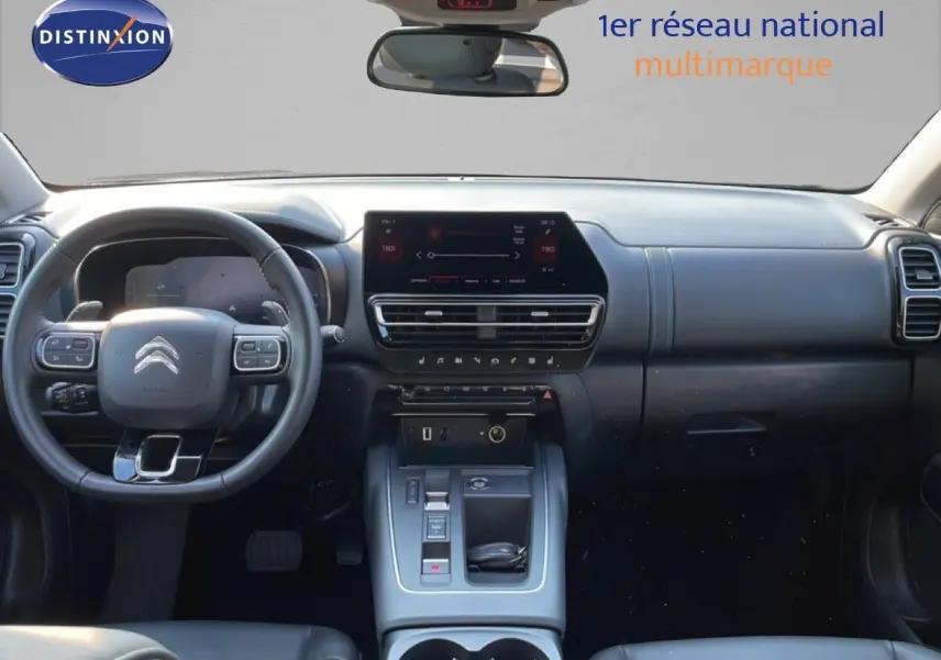 Vue intérieure avant du tableau de bord et volant du Citroën C5 Aircross bleu Eclipse Metal, avec écran tactile central et commandes modernes.