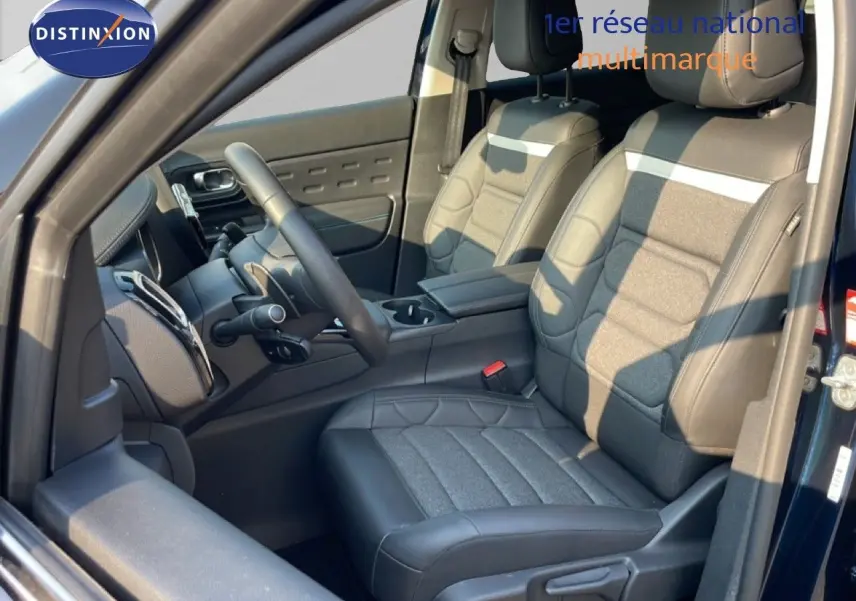 Vue intérieure côté conducteur du Citroën C5 Aircross 2025 bleu Eclipse Metal, sièges tissu et cuir noir avec console centrale.