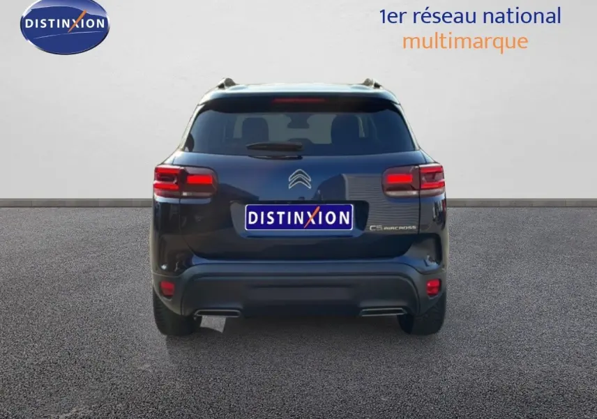 Vue arrière d'un Citroën C5 Aircross bleu Eclipse Metal 2025 avec feux arrière allumés et logo distinctif.