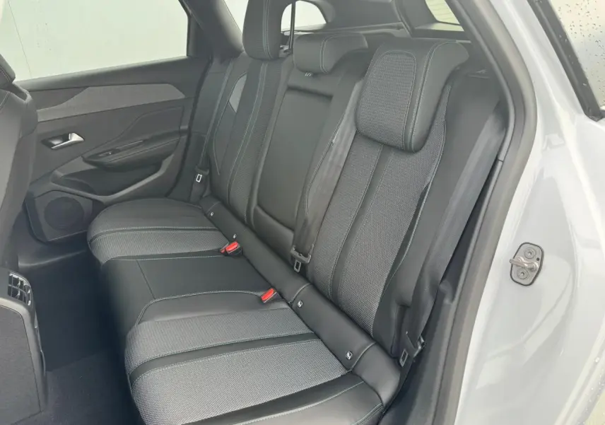 Vue côté gauche de la banquette arrière en sellerie TEP/tissu noir avec surpiqûres bleues du Peugeot 308 SW blanc Okenite 2024.