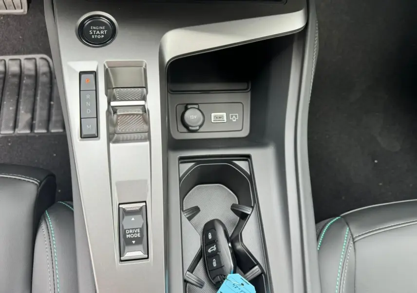 Gros plan sur la console centrale grise avec bouton start, levier de vitesses électronique et clé PEUGEOT 308 SW blanche.