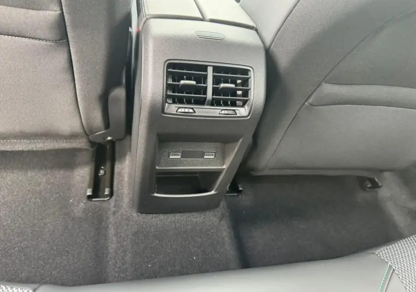 Vue rapprochée de la console centrale arrière noire avec bouches d'aération et prises USB-C du Peugeot 308 SW blanc Okenite.