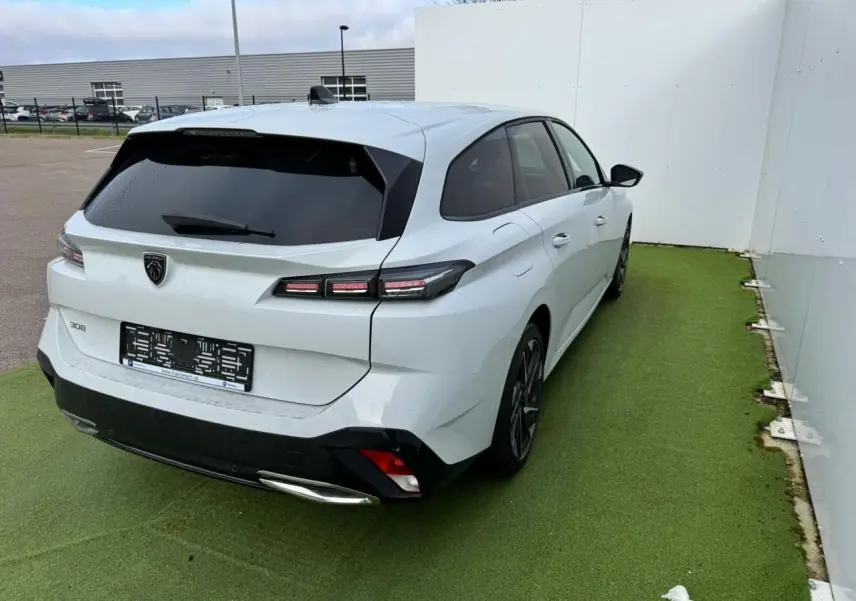 Peugeot 308 SW blanc Okenite vue 3/4 arrière droit, feux LED et jantes alliage 17'' Halong diamantées visibles.