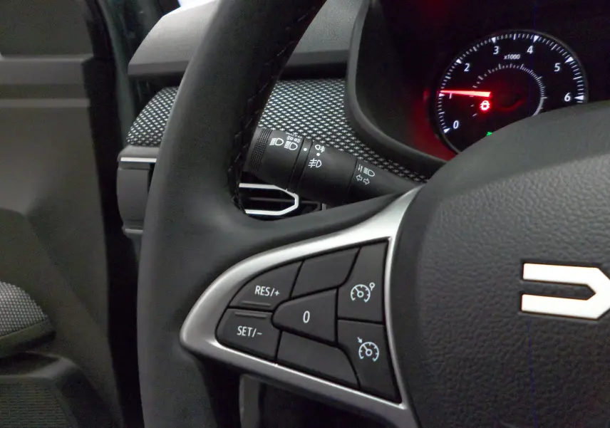 Gros plan sur le volant noir du Dacia Jogger 2025 avec commandes de régulateur de vitesse visibles.