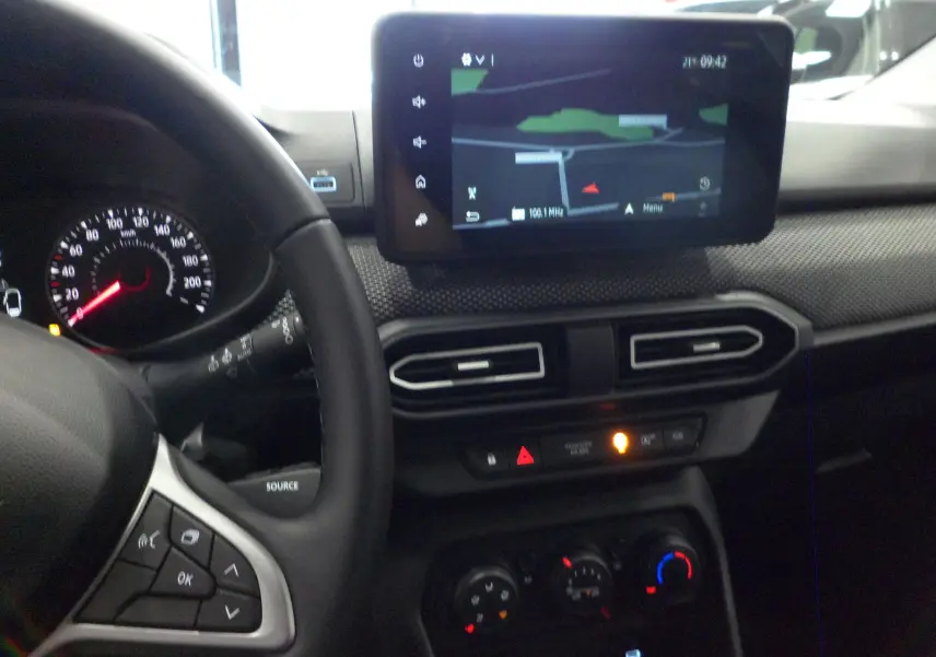 Tableau de bord du Dacia Jogger 2025 avec écran tactile central affichant la navigation, vu côté conducteur.