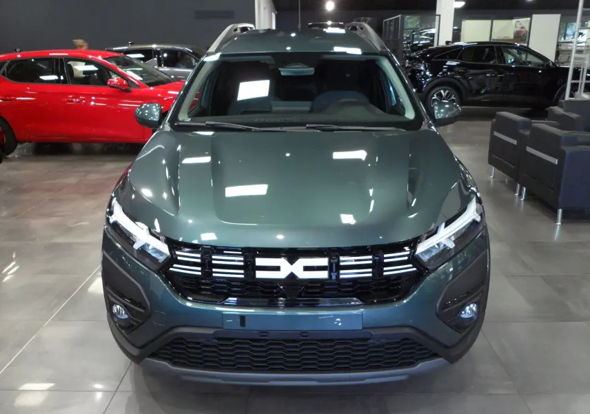 Vue frontale d'un Dacia Jogger TCe 110 vert cèdre 2025 en showroom avec calandre noire distinctive.