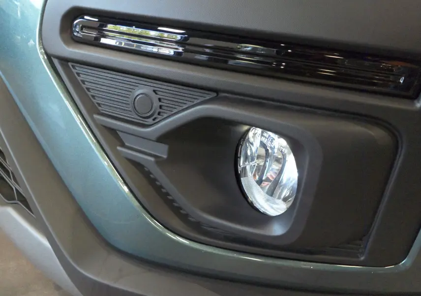 Gros plan sur le feu antibrouillard avant droit du Dacia Jogger 2025 en Vert Cèdre avec entourage noir mat.