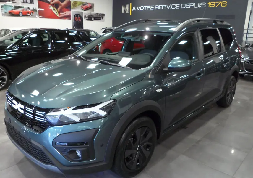 Vue 3/4 avant droite du Dacia Jogger TCe 110 Expression 7 places en Vert Cèdre, avec jantes noires et calandre moderne.