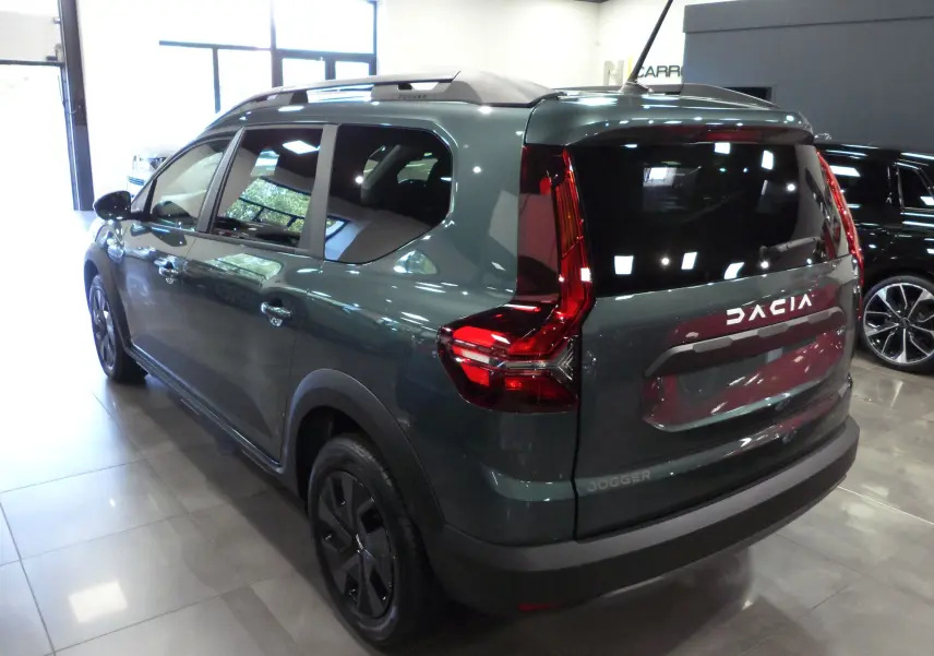 Vue 3/4 arrière droite d'une Dacia Jogger 2025 vert cèdre avec feux arrière en forme de C et toit noir.