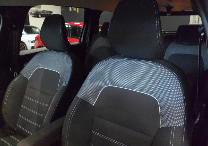 Gros plan sur les sièges avant en tissu noir et gris du Dacia Jogger 2025, version Expression 7 places, intérieur spacieux.