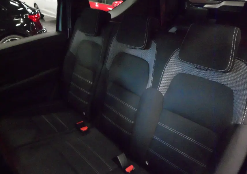 Vue intérieure sur la banquette arrière en tissu noir avec surpiqûres blanches du Dacia Jogger 2025.