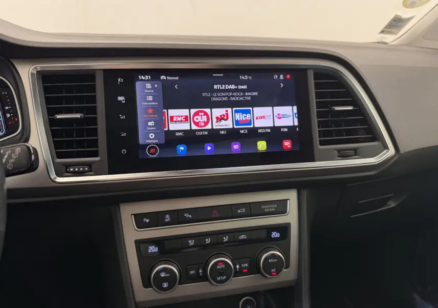 Vue rapprochée du tableau de bord noir du SEAT Ateca 2023 avec écran tactile central et commandes de climatisation.