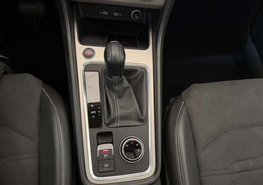 Vue plongeante sur la console centrale du SEAT Ateca gris clair, avec levier de vitesses automatique et commandes de conduite.