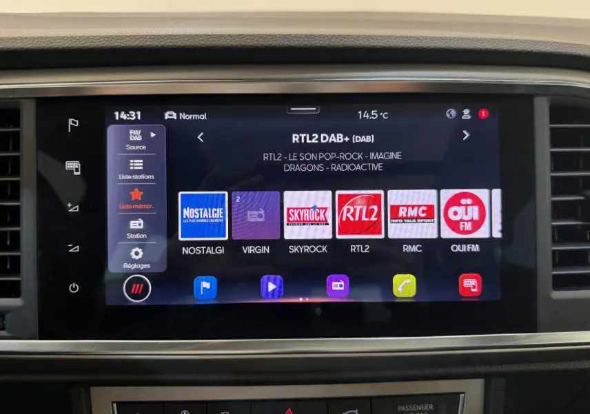 Écran tactile central affichant les stations radio dans l'habitacle d'un SEAT Ateca gris clair 2023.