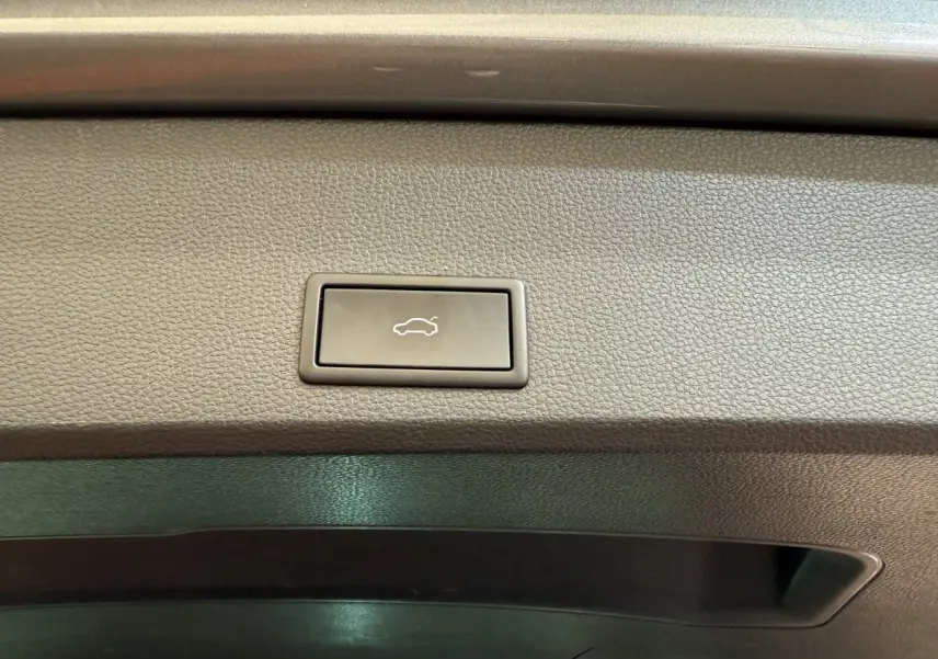 Bouton d'ouverture électrique du coffre sur la garniture intérieure gris clair du SEAT Ateca 2023.