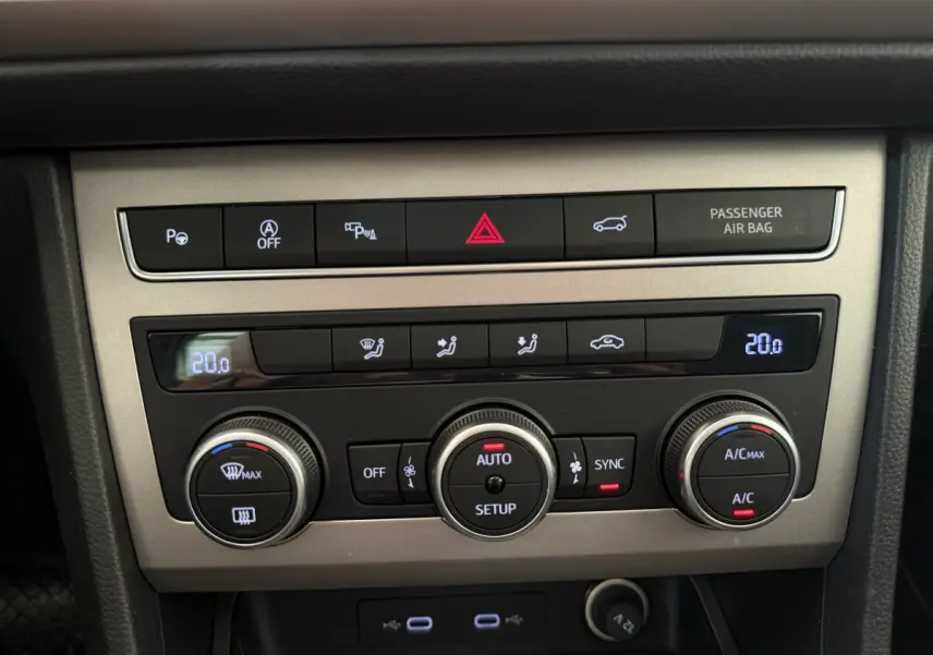 Vue rapprochée du panneau de commande de climatisation gris clair du SEAT Ateca 2023 avec affichage digital et boutons rotatifs.