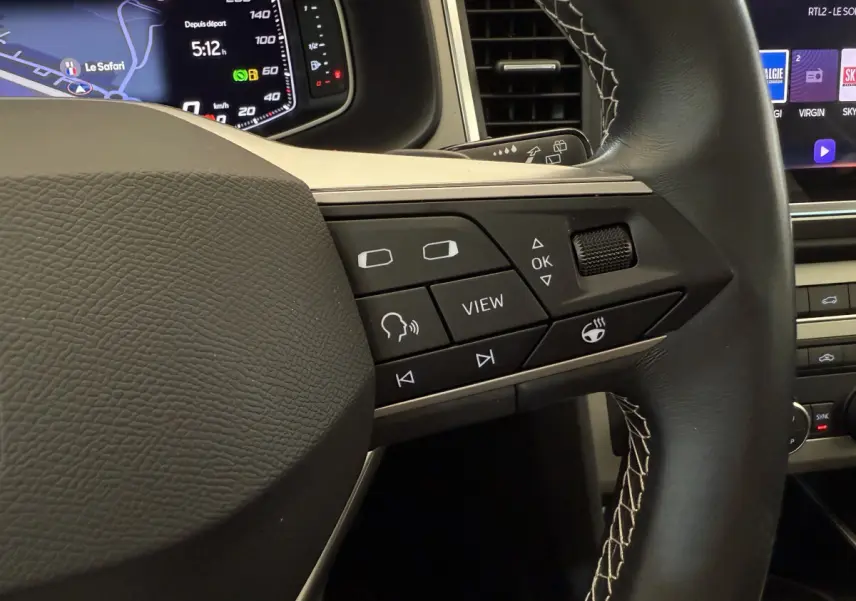 Gros plan sur le volant noir avec commandes multifonctions et affichage numérique du tableau de bord du SEAT Ateca 2023.