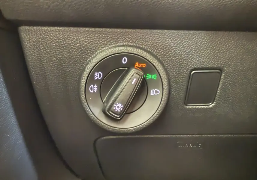 Gros plan sur la commande d'éclairage du tableau de bord noir du SEAT Ateca gris clair 2023 côté conducteur.