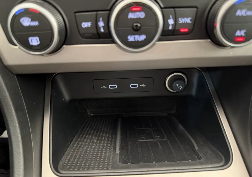 Gros plan sur la console centrale du SEAT Ateca 2023, zone de recharge sans fil et ports USB-C visibles.