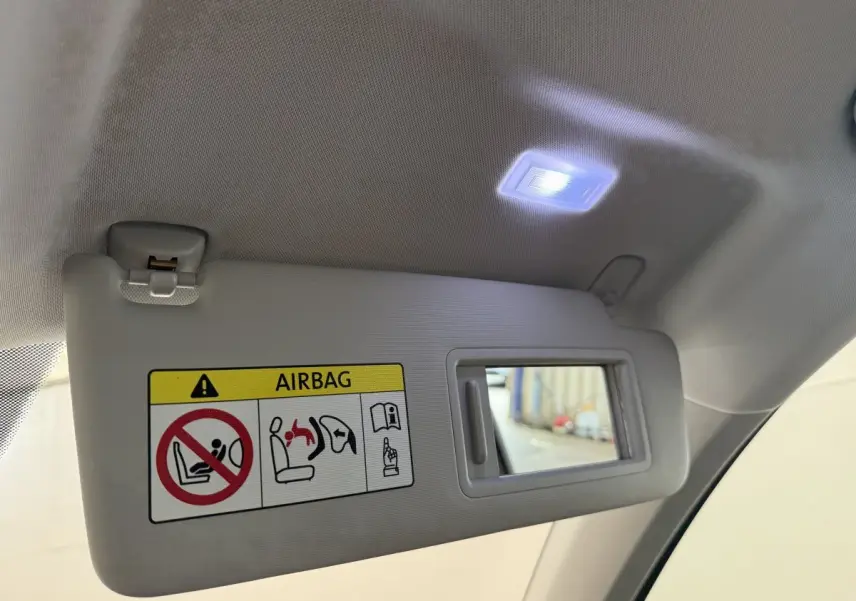 Détail du pare-soleil intérieur gris clair du SEAT Ateca 2023 avec miroir éclairé et avertissement airbag visible.