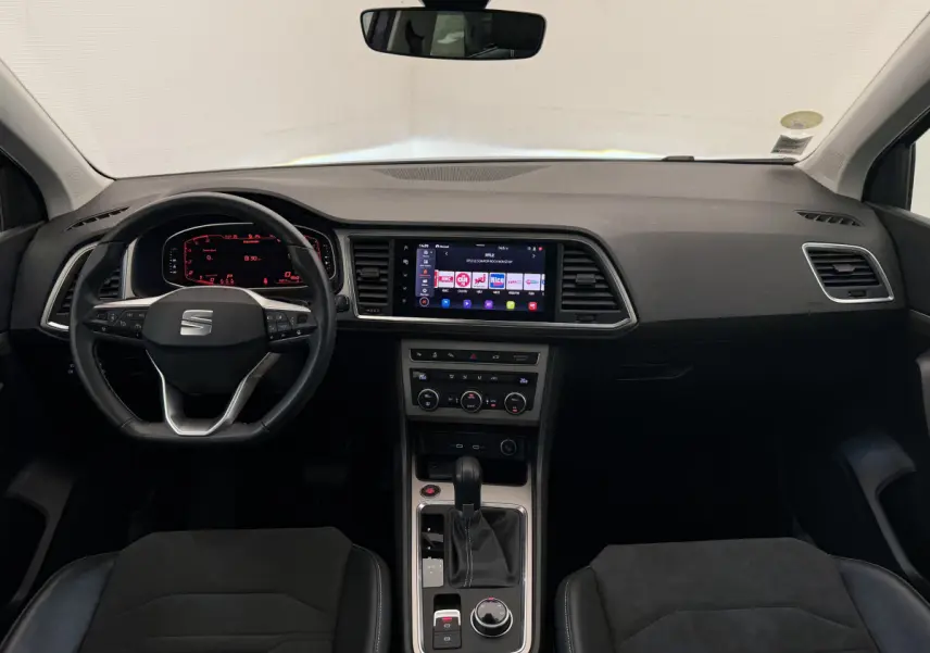 Intérieur noir du SEAT Ateca 2023, vue frontale du tableau de bord avec écran tactile central et volant multifonction.