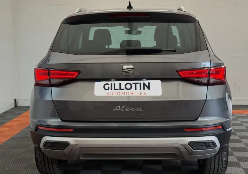 Vue arrière d'un SUV SEAT Ateca gris clair avec feux LED et double sortie d'échappement intégrée au pare-chocs.
