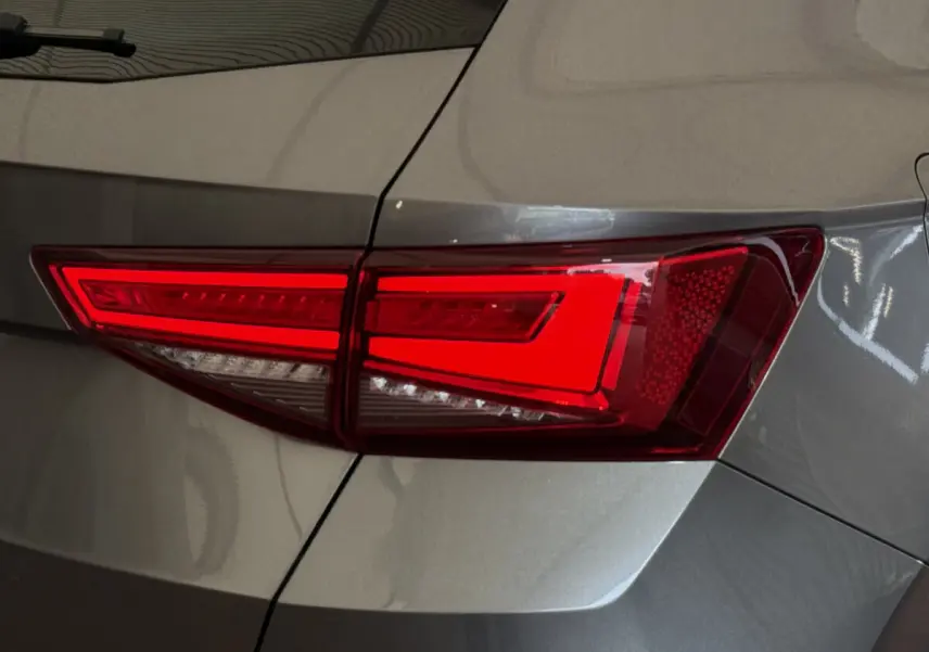 Gros plan sur le feu arrière droit rouge vif d'un SEAT Ateca gris clair 2023, soulignant ses lignes nettes.