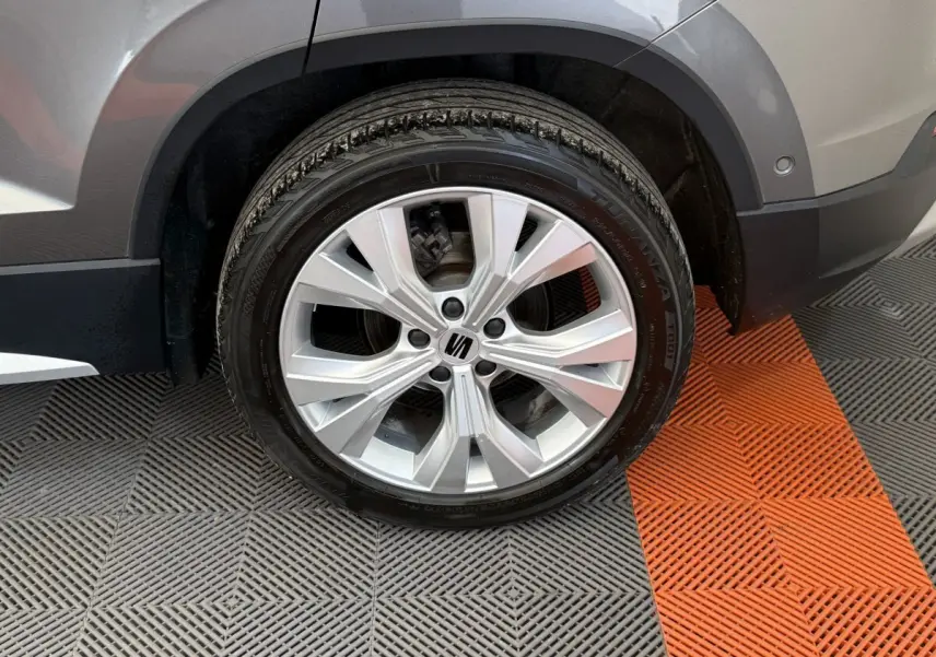 Gros plan sur la roue avant gauche gris clair du SEAT Ateca 2023 avec jante alliage et logo central noir.