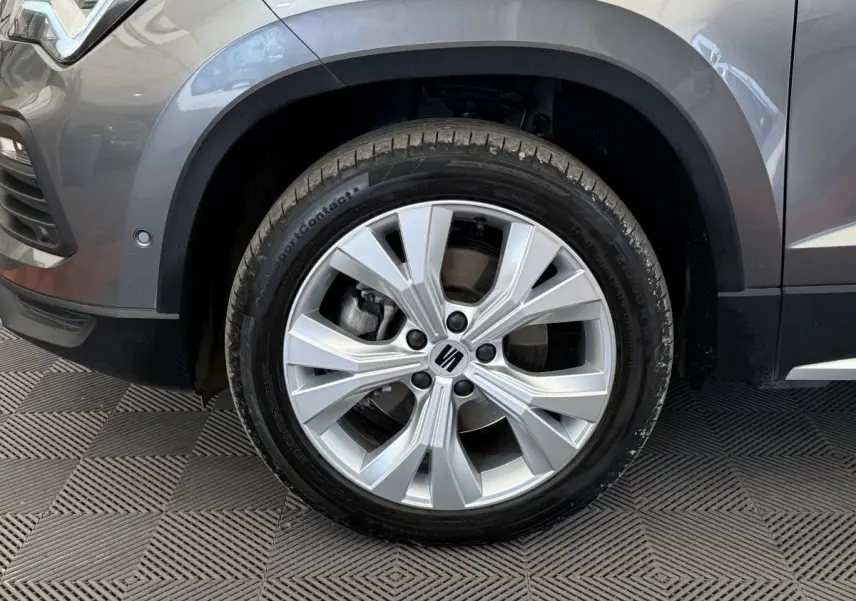 Gros plan sur la roue avant gauche gris clair du SEAT Ateca 2023 avec jante alliage et logo central visible.