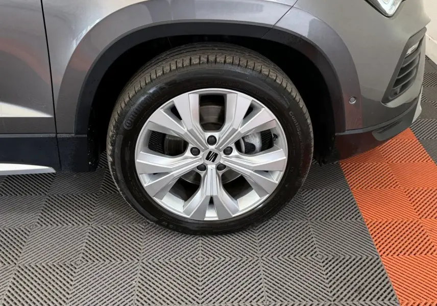 Gros plan sur la roue avant droite gris clair du SEAT Ateca 2023 avec jante alu et logo central visible.