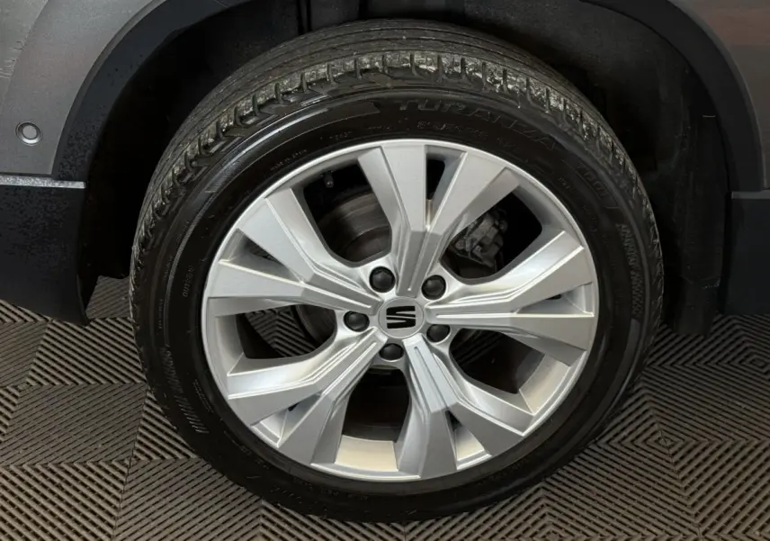 Gros plan sur la roue avant droite gris clair du SEAT Ateca 2023 avec jante alliage à 5 branches doubles.