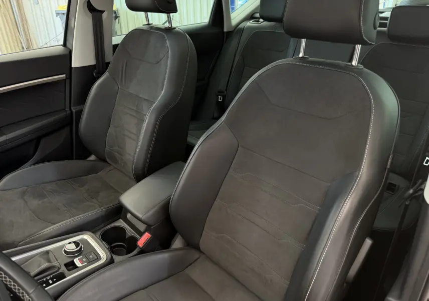 Intérieur du SEAT Ateca 2023, vue sur sièges avant en cuir noir avec surpiqûres blanches et console centrale.