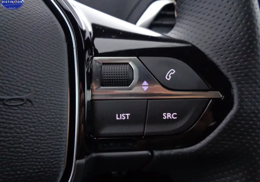 Gros plan sur les commandes noires du volant du Peugeot 3008 1.2 PureTech 130ch GT 2023, finition cuir noir.