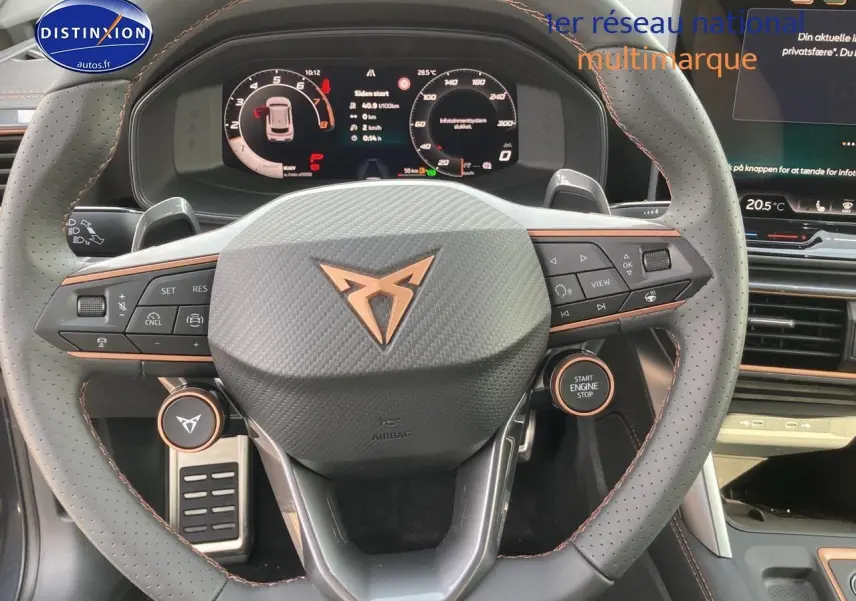 Vue rapprochée du volant cuir perforé gris avec logo CUPRA cuivre et tableau de bord numérique du Formentor 2025.