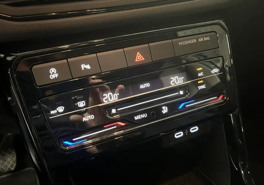 Vue rapprochée de la console centrale du Volkswagen T-Cross 2024, affichant la climatisation automatique à 20°C et ports USB-C.