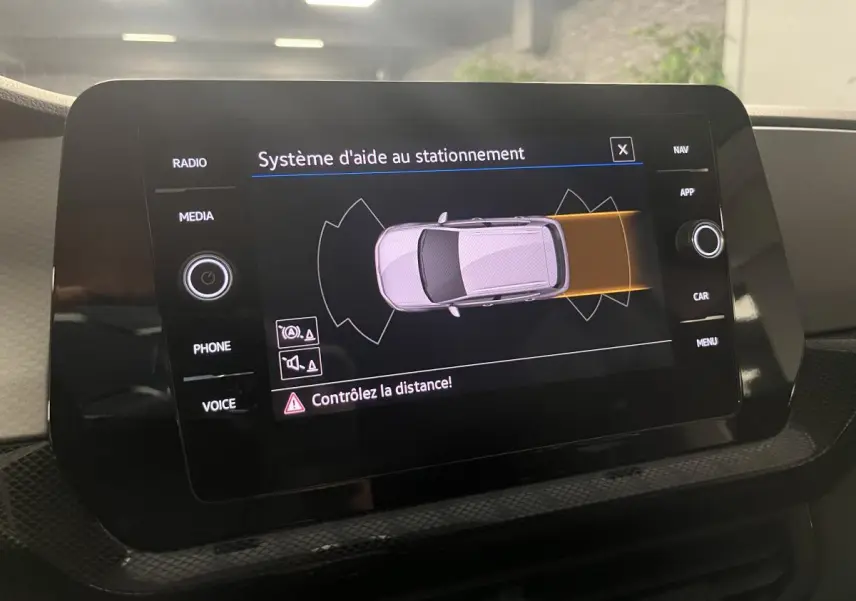 Écran tactile du système d'aide au stationnement du Volkswagen T-Cross 2024 affichant une vue du dessus du véhicule.