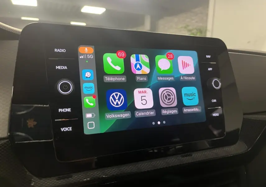 Écran tactile central du Volkswagen T-Cross 2024 affichant l'interface Apple CarPlay colorée en intérieur noir.