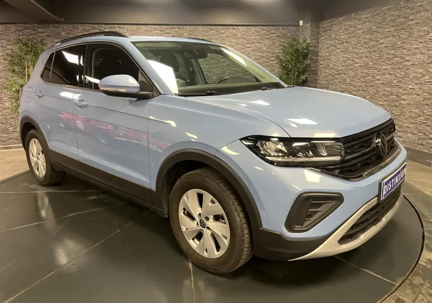 Volkswagen T-Cross bleu clair en 3/4 avant droit, avec vitres arrière surteintées et jantes alliage argent.