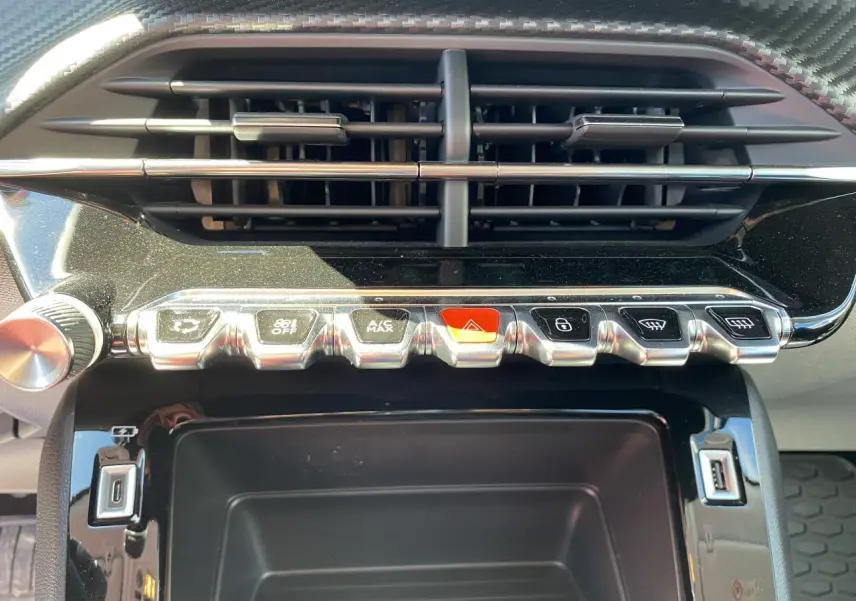 Gros plan sur la console centrale du Peugeot 2008 bleu 2021, montrant les commandes climatisation et prises USB.