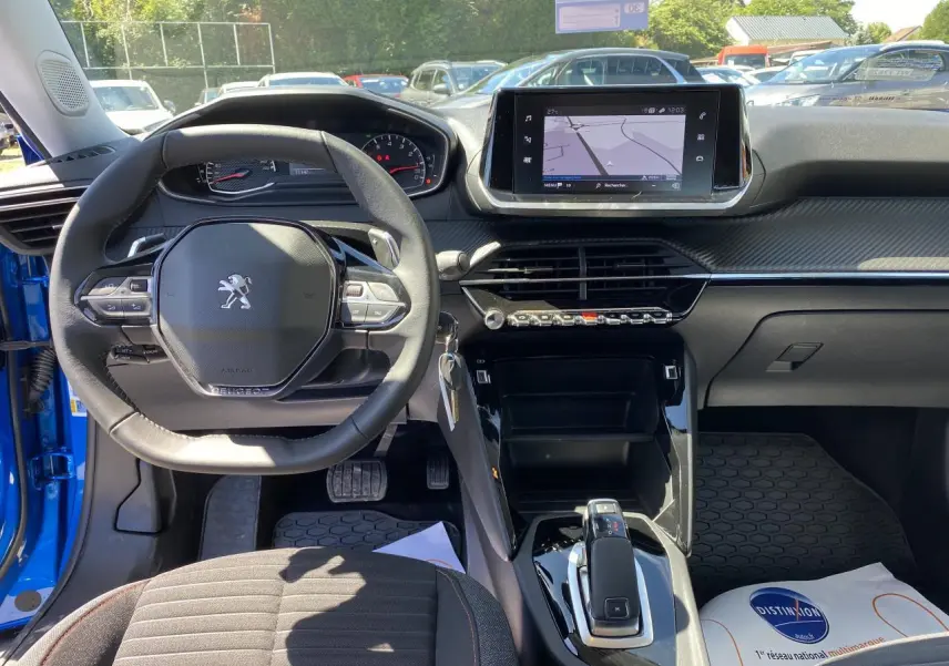 Intérieur de la Peugeot 2008 bleu 2021, vue du poste de conduite avec volant compact et écran tactile central.