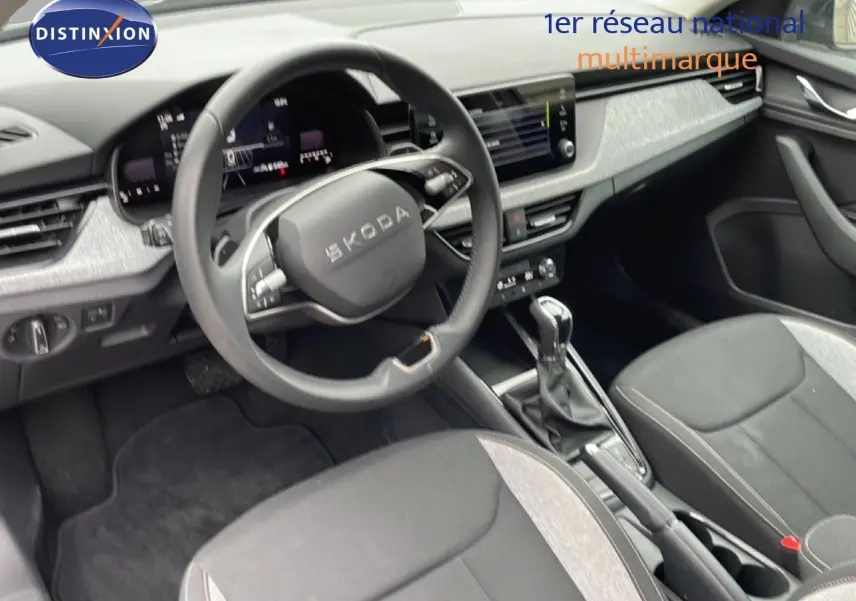 Vue intérieure côté conducteur du Skoda Kamiq 2025 gris graphite, avec volant cuir multifonction et console centrale moderne.
