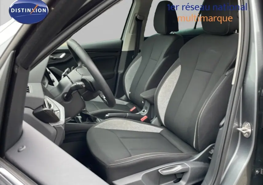 Vue intérieure côté conducteur du Skoda Kamiq 2025 gris graphite, sièges tissu noir et gris avec volant multifonction.